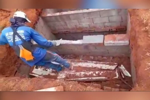 Homens pisam em ossada dentro de caixão para reformar covas